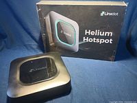 Front view of Linxdot hotspot next to branded box