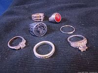 Front view of seven rings laid out on fabric