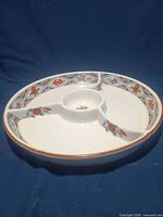 Oblique view of round porcelain platter showing three compartments and center well
