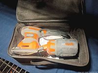 Ridgid palm sander, dust bag, manual and cord inside carry case