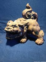 Front view of single bronze Fu Dog with green verdigris patina