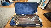Zither in open blue hard case showing interior and instrument