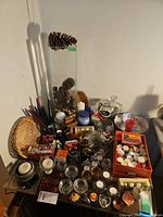 Overview of table with tall vase, multiple candles, holders, baskets