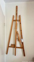 Full view of wooden easel leaning against wall