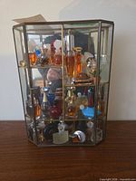 Full view of glass display case filled with miniature perfume bottles
