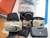 Front view of three cameras and their cases