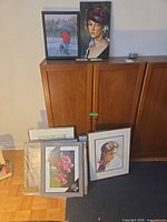 Group of eight framed and unframed paintings showing range of sizes and frames