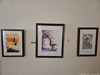 Three framed watercolor paintings mounted on wall