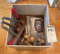 Overview of contents in storage bin showing corker, tubing, bungs, labels