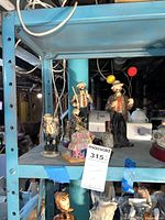 Three Flambro clown figurines on shelf, showing overall set