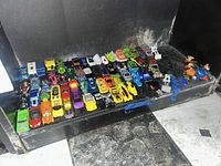 Front view of full lot showing rows of multicolor die-cast cars and figures on shelf