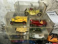 Stack of nine model vehicles in individual clear cases