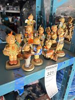 Group of eleven Goebel Hummel figurines on shelf