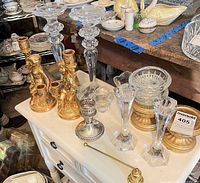 Assortment showing crystal candlesticks, gilt cherub candelabra, silver candlestick, crystal bowl, pedestal stands and snuffer