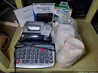 Group shot showing calculator, boxed gadgets, paper rolls