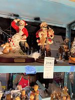 Front view of both resin Santa figurines on shelf