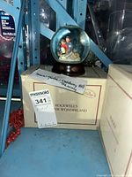 Snow globe on top of original box showing overall item