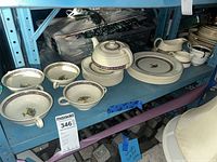 Full set on shelf showing dinner plates, soup bowls, teapot, creamer, sugar bowl