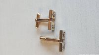 Front view showing both cufflinks, square faces, letter E and Freemason emblem