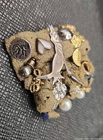 Front view showing variety of pins and earrings on fabric