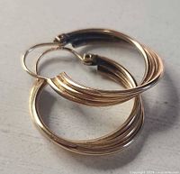 Both gold hoop earrings side by side showing ridged design