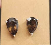 Front view showing pear-shaped smoky quartz in silver prong settings