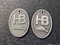 Front view of both tokens showing HB initials and beaver relief