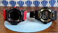 Front view of both wristwatches showing Casio G-Shock with missing module and Skmei with intact face