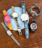 Group view of all six Guess watches on table