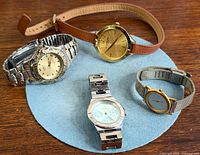 Group shot of all four watches on blue felt