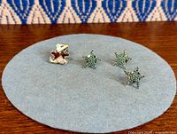 Front view of all four Swarovski pins on felt pad