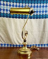 Full view of brass desk lamp showing shade, arm and base