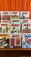 Group shot of 10 bagged MAD magazines on rack