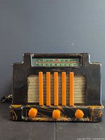 Front view of Addison Bakelite radio with orange knobs, grille bars, dial scale