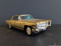Front three-quarter view of gold tin Cadillac toy car