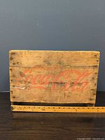 Long side of crate showing red Coca-Cola script logo