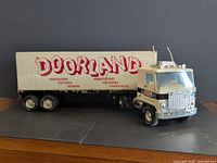 Side view of assembled cream GMC tractor with Doorland box trailer