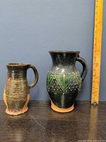 Both pitchers side by side with ruler for scale