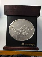 Front view showing fish plaque, signature, lid and base