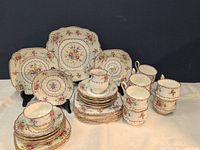 Full view of assembled tea set showing cups, saucers, plates, serving plates