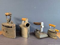 Group shot of all four cast iron irons showing overall designs and handles