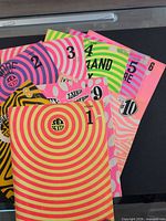 Stack of nine Sex Sexty magazines showing neon psychedelic front covers and volume numbers 1-5,8-10