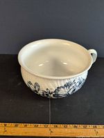 Side view of chamber pot showing floral design and scale