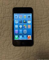 Front of Apple iPod touch powered on displaying home screen