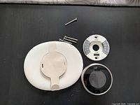Thermostat display, wall trim, mounting base and screws overview