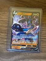 Front of Lucario V card showing artwork, stats and promo number in sleeve and top-loader