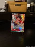Front of Monkey D. Luffy SR alt art holographic card on stand