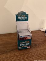 Opened OP08 Two Legends display box with stack of cards visible