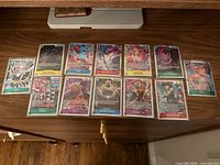 All twelve Super Rare One Piece cards laid out in two rows, each in protective sleeve