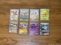 All 8 sleeved holographic cards on table